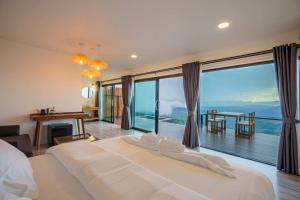 a bedroom with a large white bed and a large window at Cozy Homey Doichang in Ban Muang Ngam