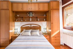 a bedroom with a bed with wooden cabinets and a window at Mila Somo in Somo