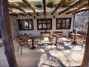 a room with tables and chairs and windows at Le casette nel verde in Lurisia