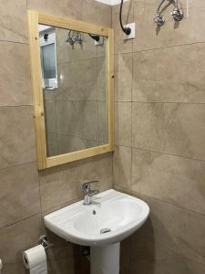 a bathroom with a sink and a mirror at Casa Tubarào in Vila do Maio
