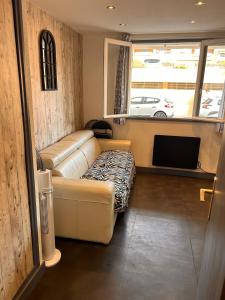 Una sala de estar con un sofá y un televisor. en Adorable studio, en Les Lecques