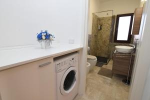a bathroom with a washer and dryer in a room at Hiram House in La Maddalena