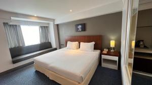 a hotel room with a bed and a window at Star Hotel Chiang Mai in Chiang Mai