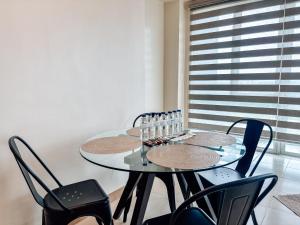 una mesa de comedor con sillas y una mesa con gafas. en Best Family Suite Experience, en Iloilo City