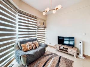 sala de estar con silla y TV de pantalla plana en Best Family Suite Experience, en Iloilo City
