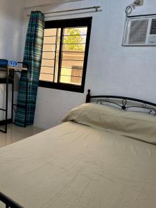 a bedroom with a bed and a window at Sebastians Crib B in Dasmariñas