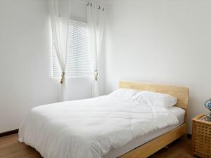 a bedroom with a bed with white sheets and a window at Marakech Seribong Homestay in Kota Bharu +7 photos