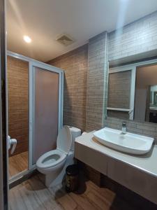 a bathroom with a toilet and a sink at Northomes Pensione by HiveRooms in Bogo