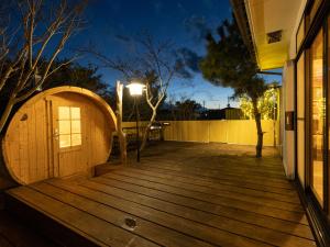 une terrasse en bois avec une porte et un bâtiment dans l'établissement ALL SEASON RESORT No6 Shiokaze, à Ichinomiya