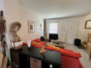 ヴェルトゥにあるBEAUTOUR VERTOU 4 people Wi-Fi TV 1 parking spaceの赤いソファとテレビのあるリビングルーム