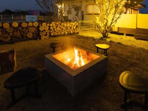 un foyer extérieur avec tabourets dans la cour la nuit dans l'établissement ALL SEASON RESORT No6 Shiokaze, à Ichinomiya