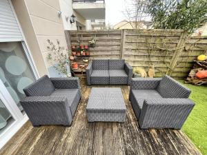 ヴェルトゥにあるBEAUTOUR VERTOU 4 people Wi-Fi TV 1 parking spaceのパティオ(籐の椅子2脚、テーブル付)