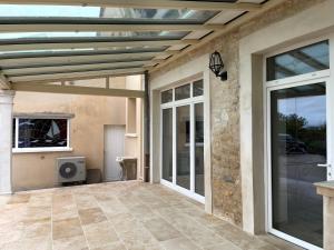 a patio with a wooden ceiling and glass doors at Lepigeonnier de Papy in Dijon