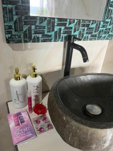 a bathroom counter with a sink and two bottles of soap at D’Taman cabin Kintamani in Kubupenlokan