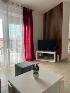 salon z telewizorem i białym stołem w obiekcie Apartmani Krišto 2 Zadar w mieście Zadar