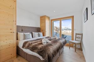 una camera da letto con un letto grande con una grande finestra di Chalet Marmotte, à seulement 50m de la piste a Veysonnaz