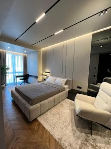 a bedroom with a large bed and a chair at Royal Class of the City centre-Adults Only in Chişinău