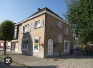 a large brick building with a white door on a street at Ju-Jolie in Bruges