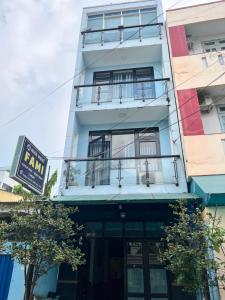 een wit gebouw met een bord ervoor bij Nhà Nghỉ FAMI in Ho Chi Minh-stad