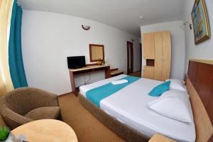 a bedroom with a large bed and a chair at Hotel Miorita Neptun in Neptun +12 photos