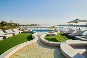a swimming pool with lounge chairs and the water at Mövenpick Royal Lotus Nile Cruise, Every Monday Four Nights From Luxor, Every Friday Three Nights From Aswan - Including Excursions & Sightseeing in Luxor