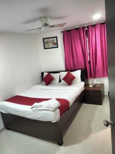 a bedroom with a large bed with red curtains at Room sunflower in Mumbai
