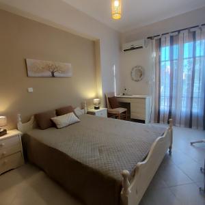 a bedroom with a bed and a desk and a window at Christina's house in Kipséli