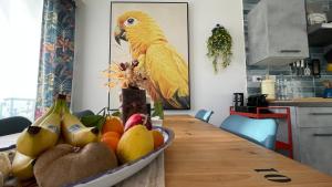 a bowl of fruit on a table with a parrot at Koru House Torvaianica in Torvaianica