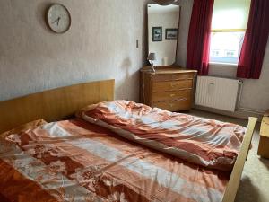 a bedroom with a bed and a clock on the wall at Schönes Fachwerkhaus Lauterbach in Lauterbach
