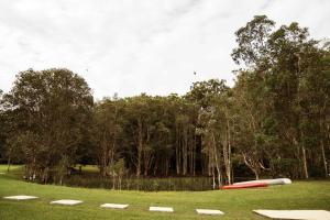a group of frisbees in a field with trees at Farmhouse 1 at Coffs by Tiny Away in Boambee