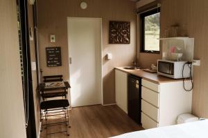 a small kitchen with a sink and a microwave at Farmhouse 1 at Coffs by Tiny Away in Boambee