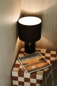 a lamp on top of a table with a magazine at Farmhouse 1 at Coffs by Tiny Away in Boambee +23 photos