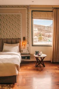 巴德里纳特New Hotel Snow Crest的一间带床、窗户和桌子的卧室