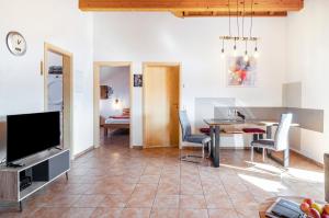 a living room with a dining table and a television at Obstgut Mit Herz Thomas Maier in Stockach