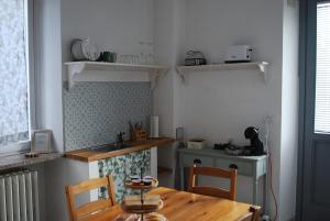 a small kitchen with a wooden table and a sink at Le stanze di Alicam in Arona