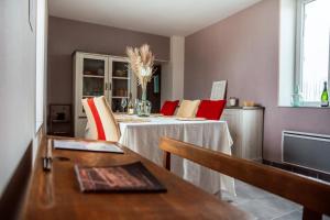 a dining room with two tables and a television at le refuge des cépages - essoyes in Essoyes