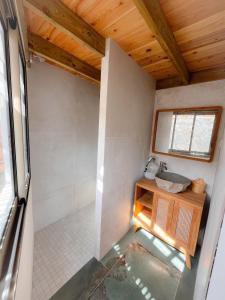 a small bathroom with a shower and a sink at Paillote Plume Bleue in Saint-Leu