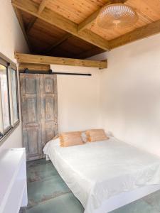 a bedroom with a bed and a wooden ceiling at Paillote Plume Bleue in Saint-Leu