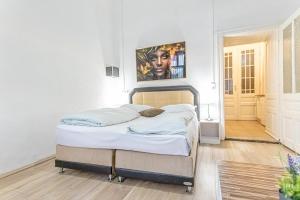 sypialnia z łóżkiem i obrazem na ścianie w obiekcie Chic Apartment- Suitable for Longstays near Matzleinsforferplatz w Wiedniu