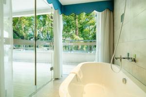 un bagno con vasca e ampia finestra di Guilin O-LIVE Social Hotel -Riverside -Adjacent Elephant Hill -Pedestrian Street-Twin Towers-Mediterranean style a Guilin