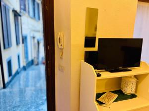 a desk with a television on a yellow wall at Gigi House in Verbania