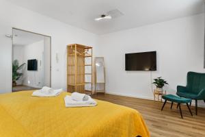 ein Schlafzimmer mit einem gelben Bett mit zwei Handtüchern darauf in der Unterkunft ROTH Apartments Solingen-HBF in Solingen