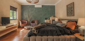 a living room with a large bed and a couch at YEBO Boutique Guesthouse in Somerset West