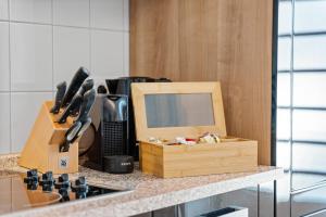 eine Küchentheke mit einem Schneidebrett und einem Messerblock in der Unterkunft ROTH Apartments Solingen-HBF in Solingen