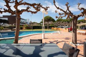 a courtyard with a pool with trees and a light pole at Panoramic view Gavà Mar in Gavà