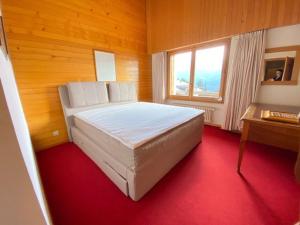 a bedroom with a large white bed in a wooden room at Christiania 431 in Bagnes