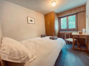 a bedroom with a bed and a desk and a table at Christiania 431 in Bagnes