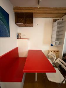a red table and a red bench in a room at James Joyce - Metro Cubo in Trieste