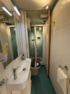 a bathroom with a sink and a toilet and a mirror at James Joyce - Metro Cubo in Trieste