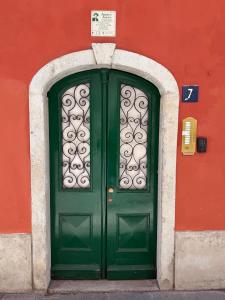 a green door on a red building with a sign above it at James Joyce - Metro Cubo in Trieste